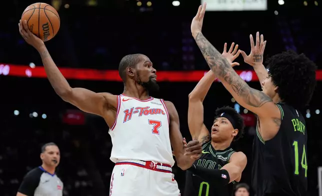 Houston Rockets forward Kevin Durant (7) looks to pass over New Orleans Pelicans guard Jeremiah Fears (0) and guard Micah Peavy (14) during the second half of an NBA basketball game in Houston, Sunday, Jan. 18, 2026. (AP Photo/Ashley Landis)