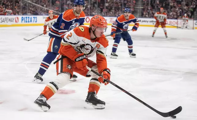 Anaheim Ducks' Jackson LaCombe, front,is chased by Edmonton Oilers' Evan Bouchard, behind, during first-period NHL hockey game action in Edmonton, Alberta, Monday, Jan. 26, 2026. (Jason Franson/The Canadian Press via AP)