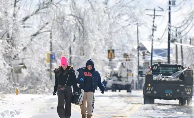 Arriana Delguerra, left, and Cera Lacomb walk on the icy streets in Oxford, Miss. on Monday, Jan. 26, 2026. (AP Photo/Bruce Newman)