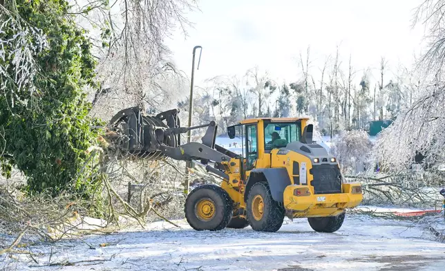 A worker clears trees from the roadway in Oxford, Miss. on Monday, Jan. 26, 2026, following a weekend ice storm. (AP Photo/Bruce Newman)