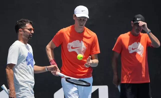 Jannik Sinner of Italy talks with coach Simone Vagnozzi, left, during a practice session ahead of the Australian Open tennis championship in Melbourne, Australia, Friday, Jan. 16, 2026. (AP Photo/Dita Alangkara)