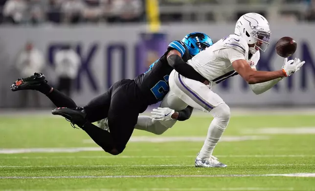 Minnesota Vikings wide receiver Justin Jefferson, right, catches a pass past Detroit Lions cornerback Rock Ya-Sin during the second half of an NFL football game, Thursday, Dec. 25, 2025, in Minneapolis. (AP Photo/Abbie Parr)