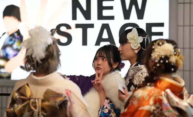 Young adults arrive to celebrate the Coming-of-Age Day, a centuries-old tradition and national holiday marking the milestone from childhood to adulthood, Monday, Jan. 12, 2026, in Yokohama near Tokyo. (AP Photo/Eugene Hoshiko)