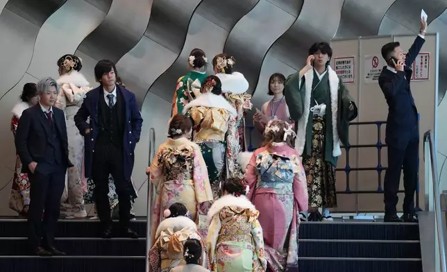 Young adults arrive at a venue to celebrate the Coming-of-Age Day, a centuries-old tradition and national holiday marking the milestone from childhood to adulthood, Monday, Jan. 12, 2026, in Yokohama near Tokyo. (AP Photo/Eugene Hoshiko)
