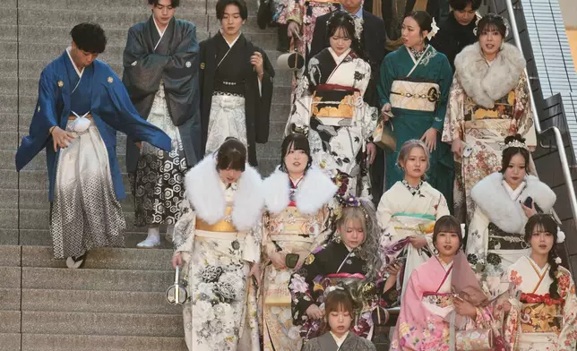 Young adults arrive at a venue to celebrate the Coming-of-Age Day, a centuries-old tradition and national holiday marking the milestone from childhood to adulthood, Monday, Jan. 12, 2026, in Yokohama near Tokyo. (AP Photo/Eugene Hoshiko)