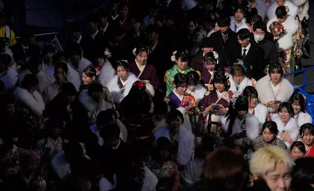 Young adults leave a venue after celebrating the Coming-of-Age Day, a centuries-old tradition and national holiday marking the milestone from childhood to adulthood, Monday, Jan. 12, 2026, in Yokohama near Tokyo. (AP Photo/Eugene Hoshiko)