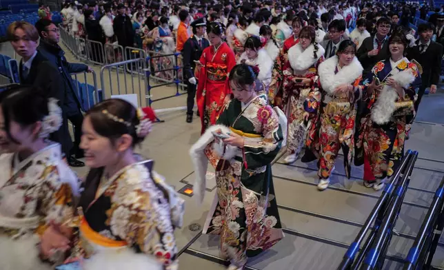 Young adults leave a venue after marking the Coming-of-Age Day, a centuries-old tradition and national holiday marking the milestone from childhood to adulthood, Monday, Jan. 12, 2026, in Yokohama near Tokyo. (AP Photo/Eugene Hoshiko)
