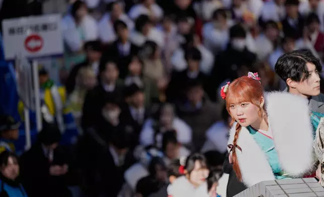 Young adults leave a venue after celebrating the Coming-of-Age Day, a centuries-old tradition and national holiday marking the milestone from childhood to adulthood, Monday, Jan. 12, 2026, in Yokohama near Tokyo. (AP Photo/Eugene Hoshiko)
