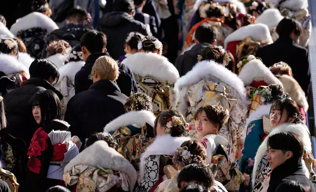 Young adults leave a venue after celebrating the Coming-of-Age Day, a centuries-old tradition and national holiday marking the milestone from childhood to adulthood, Monday, Jan. 12, 2026, in Yokohama near Tokyo. (AP Photo/Eugene Hoshiko)