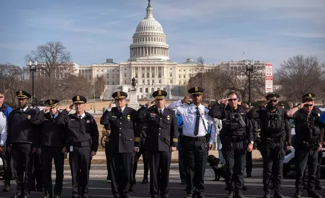 U.S. Capitol Police officers salute as a van carrying the body of Metropolitan Police Department officer Terry Bennett is driven past the Capitol, Thursday, Jan. 8, 2026, in Washington. (AP Photo/Mark Schiefelbein)