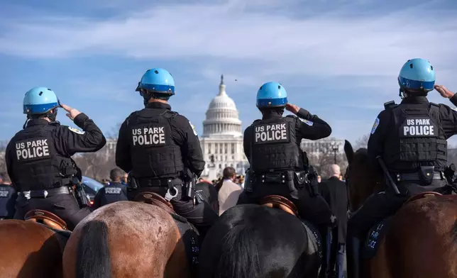 U.S. Park Police mounted officers salute as a van carrying the body of Metropolitan Police Department officer Terry Bennett is driven past the Capitol, Thursday, Jan. 8, 2026, in Washington. (AP Photo/Mark Schiefelbein)