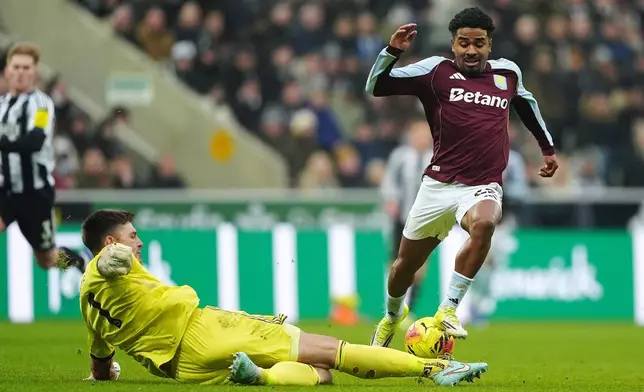 Aston Villa's Ian Maatsen, right, is tackled by Newcastle United goalkeeper Nick Pope during their English Premier League soccer match in Newcastle upon Tyne, England, Sunday, Jan. 25, 2026. (Owen Humphreys/PA via AP)