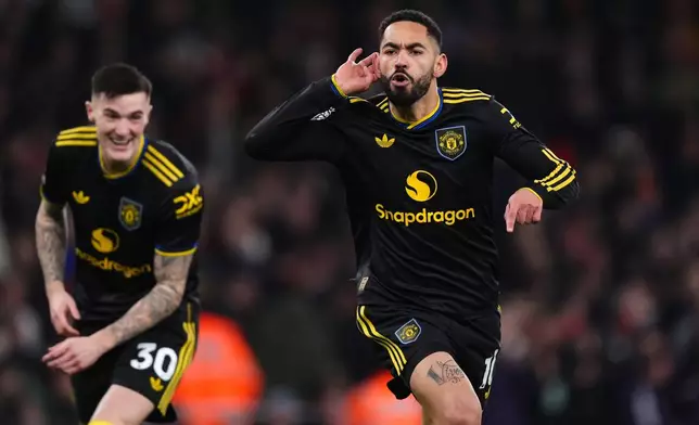 Manchester United's Matheus Cunha celebrates scoring their side's third goal of the game during the English Premier League soccer match between Arsenal and Manchester United in London, Sunday, Jan. 25, 2026. (Mike Egerton/PA via AP)