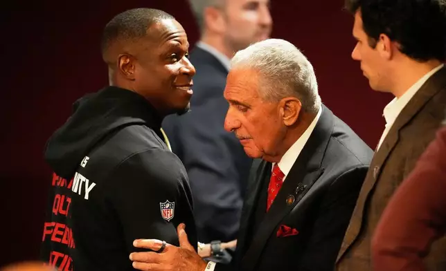 Atlanta Falcons owner Arthur Blank, right, hugs head coach Raheem Morris after an NFL football game against the New Orleans Saints, Sunday, Jan. 4, 2026, in Atlanta. (AP Photo/Mike Stewart)