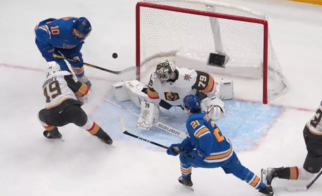 St. Louis Blues' Brayden Schenn (10) scores past Vegas Golden Knights goaltender Carter Hart (79) and Ivan Barbashev (49) as teammate Jimmy Snuggerud (21) watches during the third period of an NHL hockey game Friday, Jan. 2, 2026, in St. Louis. (AP Photo/Jeff Roberson)