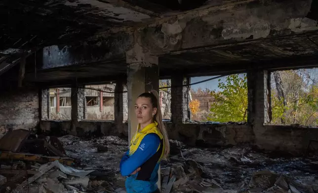 Biathlete Khrystyna Dmytrenko poses for photos inside the destroyed ski base in Chernihiv, Ukraine, Thursday, Oct. 30, 2025. (AP Photo/Julia Demaree Nikhinson)
