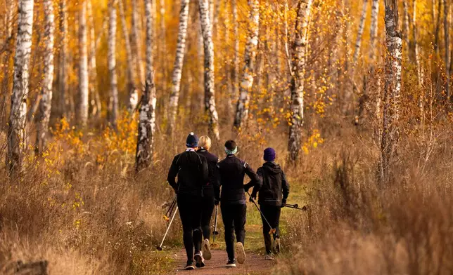 Biathletes Yekateryna Mashtalier, 18, Mykola Dorofeiev, 16, Maksym Kravchenko, 17, and Nazar Kravchenko, 12, run during a training session at the ski base in Chernihiv, Ukraine, Thursday, Oct. 30, 2025. (AP Photo/Julia Demaree Nikhinson)