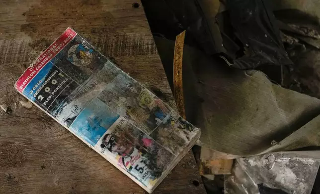 A 2001 Biathlon World Championships brochure lays in the rubble of the Chernihiv, Ukraine ski base, which was destroyed following Russian attacks in 2022, Thursday, Oct. 30, 2025. (AP Photo/Julia Demaree Nikhinson)