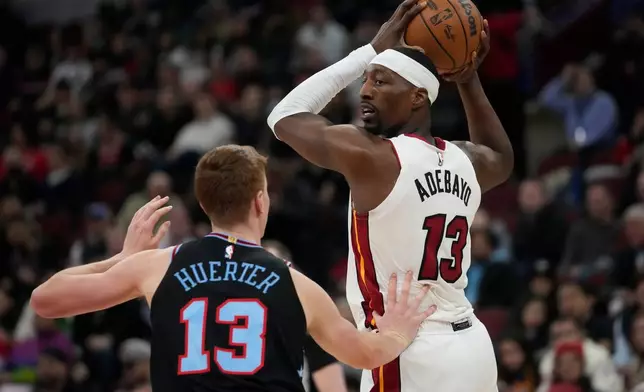 Chicago Bulls guard Kevin Huerter (13), left, guards Miami Heat center Bam Adebayo (13) during the first half of an NBA basketball game, Thursday, Jan. 29, 2026, in Chicago. (AP Photo/Erin Hooley)