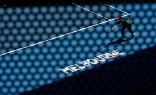 Raphael Collignon of Belgium plays a backhand return to Lorenzo Musetti of Italy during their first round match at the Australian Open tennis championship in Melbourne, Australia, Tuesday, Jan. 20, 2026. (AP Photo/Aaron Favila)
