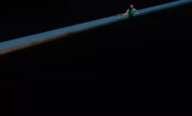 Raphael Collignon of Belgium plays a forehand return to Lorenzo Musetti of Italy during their first round match at the Australian Open tennis championship in Melbourne, Australia, Tuesday, Jan. 20, 2026. (AP Photo/Aaron Favila)