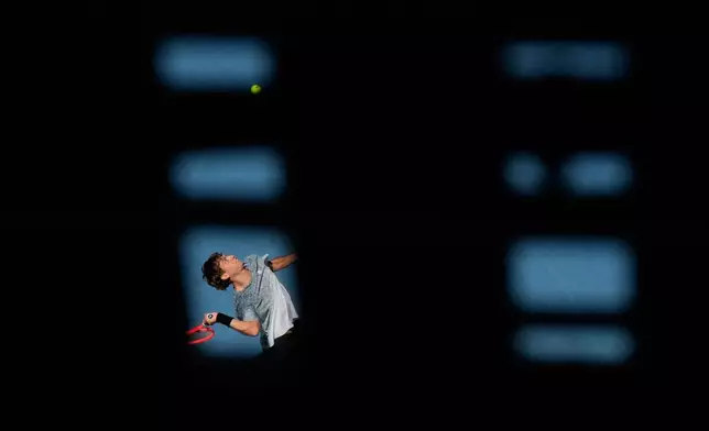 Flavio Cobolli of Italy serves to Arthur Fery of Britain during their first round match at the Australian Open tennis championship in Melbourne, Australia, Sunday, Jan. 18, 2026. (AP Photo/Aaron Favila)