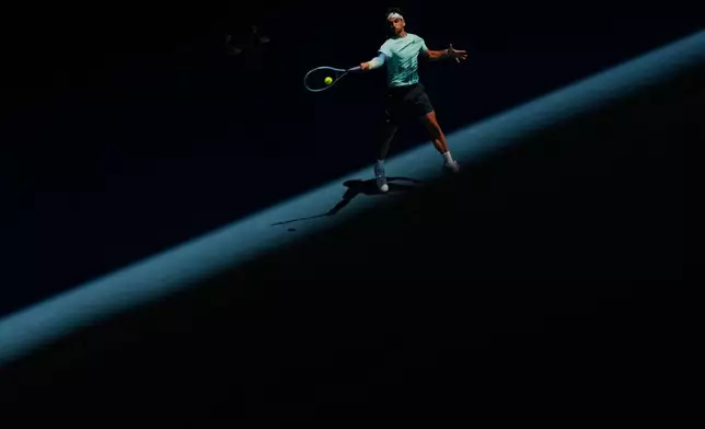 Lorenzo Musetti of Italy plays a forehand return to Raphael Collignon of Belgium during their first round match at the Australian Open tennis championship in Melbourne, Australia, Tuesday, Jan. 20, 2026. (AP Photo/Aaron Favila)