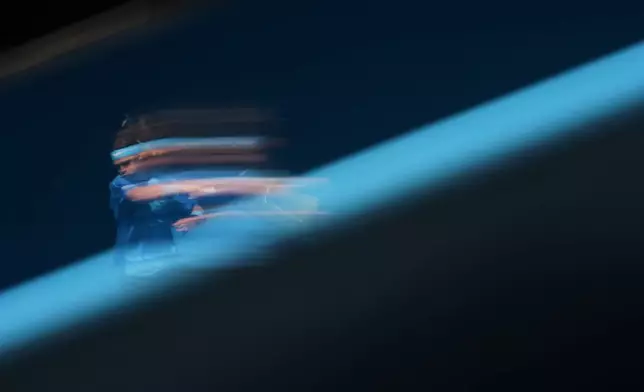 In this image taken with a slow shutter speed, Andrey Rublev of Russia plays a forehand return to Jaime Faria of Portugal during their second round match at the Australian Open tennis championship in Melbourne, Australia, Wednesday, Jan. 21, 2026. (AP Photo/Asanka Brendon Ratnayake)