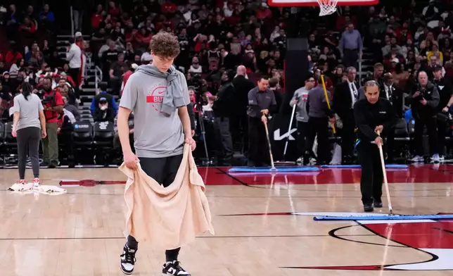 United Center employees try to dry the court before an NBA basketball game between the Miami Heat and the Chicago Bulls in Chicago, Thursday, Jan. 8, 2026. (AP Photo/Nam Y. Huh)