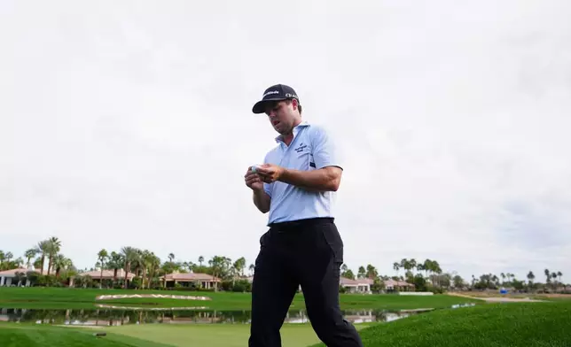 Pierceson Coody looks at his golf ball as he walks off the 18th green during the first round of the American Express golf event at Jack Nicklaus Tournament Course at PGA West Thursday, Jan. 22, 2026, in La Quinta, Calif. (AP Photo/Ross D. Franklin)