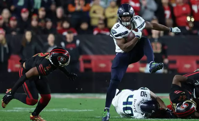 Seattle Seahawks running back Kenneth Walker III (9) runs against San Francisco 49ers cornerback Deommodore Lenoir (2) during the second half of an NFL football game in Santa Clara, Calif., Saturday, Jan. 3, 2026. (AP Photo/Jed Jacobsohn)
