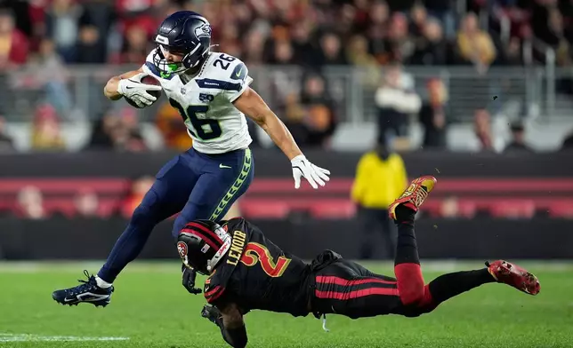 Seattle Seahawks running back Zach Charbonnet (26) runs against San Francisco 49ers cornerback Deommodore Lenoir (2) during the second half of an NFL football game in Santa Clara, Calif., Saturday, Jan. 3, 2026. (AP Photo/Godofredo A. Vásquez)