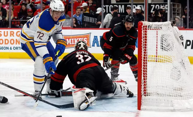 Buffalo Sabres' Tage Thompson (72) tries to get the puck as it slips by Carolina Hurricanes goaltender Brandon Bussi (32) with Hurricanes' Jalen Chatfield (5) nearby during the third period of an NHL hockey game in Raleigh, N.C., Monday, Jan. 19, 2026. (AP Photo/Karl DeBlaker)