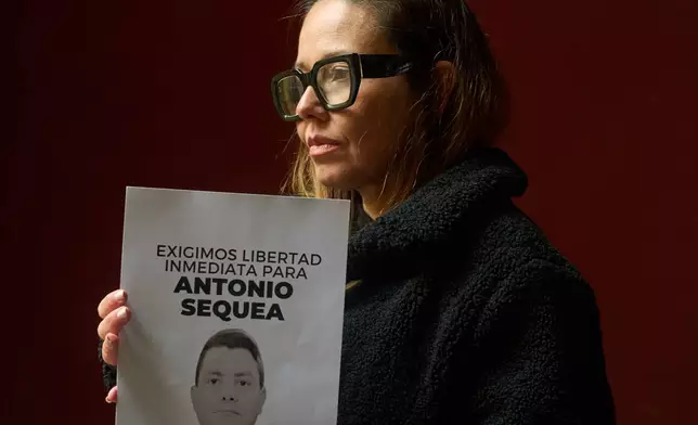 Veronica Noya holds a picture of her husband Antonio Sequea in Madrid, Thursday, Jan. 15, 2026. (AP Photo/Bernat Armangue)