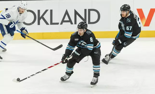 Utah Mammoth center Nick Schmaltz (8) moves the puck on the ice against Toronto Maple Leafs center Steven Lorentz (18) during the third period of an NHL hockey game Tuesday, Jan. 13, 2026, in Salt Lake City. (AP Photo/Melissa Majchrzak)