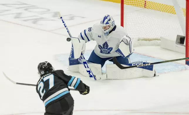 Utah Mammoth center Barrett Hayton (27) shoots the puck against Toronto Maple Leafs goalie Dennis Hildeby (35) during the third period of an NHL hockey game Tuesday, Jan. 13, 2026, in Salt Lake City. (AP Photo/Melissa Majchrzak)