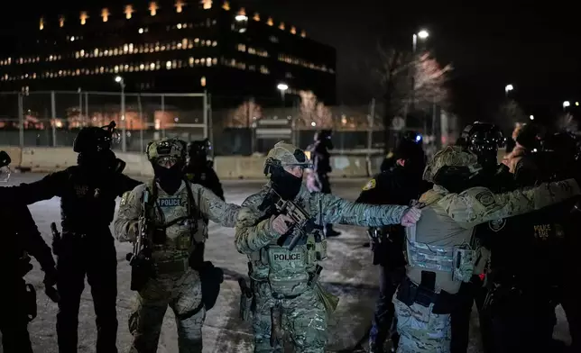 Federal immigration officers confront protesters outside Bishop Henry Whipple Federal Building, Thursday, Jan. 15, 2026, in Minneapolis. (AP Photo/Yuki Iwamura)