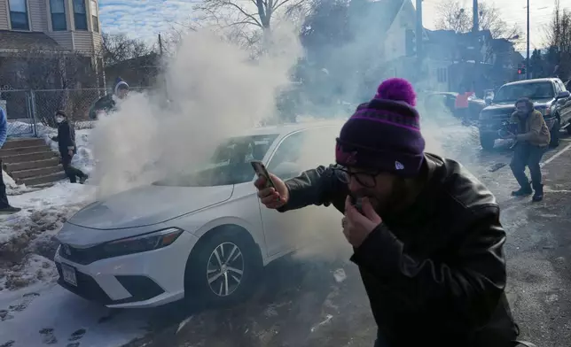Protesters try to avoid tear gas dispersed by federal agents, Monday, Jan. 12, 2026 in Minneapolis (AP Photo/Adam Gray)