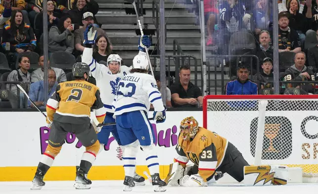 Toronto Maple Leafs center John Tavares, second from left, scores against Vegas Golden Knights goaltender Adin Hill (33) during the second period of an NHL hockey game Thursday, Jan. 15, 2026, in Las Vegas. (AP Photo/Candice Ward)