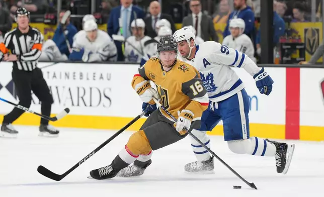 Vegas Golden Knights right wing Pavel Dorofeyev (16) skates with the puck against Toronto Maple Leafs center John Tavares, right, during the first period of an NHL hockey game Thursday, Jan. 15, 2026, in Las Vegas. (AP Photo/Candice Ward)