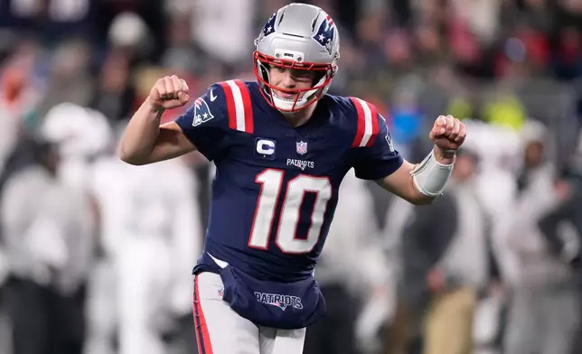 New England Patriots quarterback Drake Maye celebrates after a touchdown scored by running back TreVeyon Henderson during the second half of an NFL football game against the Miami Dolphins in Foxborough, Mass., Sunday, Jan. 4, 2026. (AP Photo/Charles Krupa)