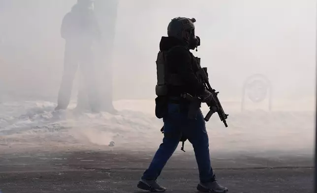 Federal immigration officers deploy tear gas after a shooting Saturday, Jan. 24, 2026, in Minneapolis. (AP Photo/Abbie Parr)