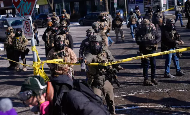 Federal immigration officers deploy pepper spray at protesters after a shooting Saturday, Jan. 24, 2026, in Minneapolis. (AP Photo/Abbie Parr)
