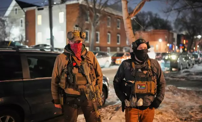 EDS NOTE: OBSCENITY - Armed community response members patrol near the scene where 37-year-old Alex Pretti was fatally shot by a U.S. Border Patrol officer earlier in the day, Saturday, Jan. 24, 2026, in Minneapolis. (AP Photo/Adam Gray)