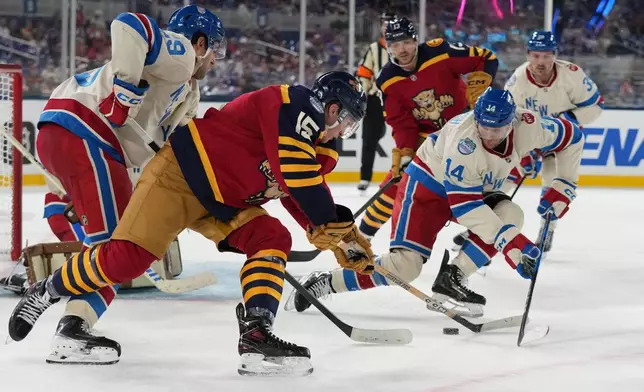 Florida Panthers center Anton Lundell (15) and New York Rangers right wing Taylor Raddysh (14) vie for the puck during the third period of the NHL Winter Classic outdoor hockey game, Friday, Jan. 2, 2026, in Miami. (AP Photo/Lynne Sladky)