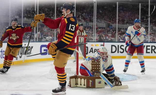 Florida Panthers center Sam Reinhart (13) celebrates after scoring against New York Rangers goaltender Igor Shesterkin (31) during the third period of the NHL Winter Classic outdoor hockey game, Friday, Jan. 2, 2026, in Miami. (AP Photo/Lynne Sladky)