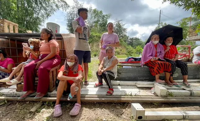 Family members and relatives wait as rescuers continue operations on a collapsed waste segregation facility in Binaliw, Cebu city, central Philippines on Saturday, Jan. 10, 2026. (AP Photo/Jacqueline Hernandez)