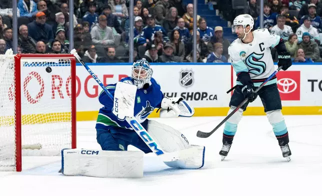 Seattle Kraken's Vince Dunn, not seen, scores a goal that was later disallowed, on Vancouver Canucks goaltender Thatcher Demko (35), as Seattle's Jordan Eberle (7) watches, during overtime NHL hockey action in Vancouver, Friday, Jan. 2, 2026. (Ethan Cairns/The Canadian Press via AP)