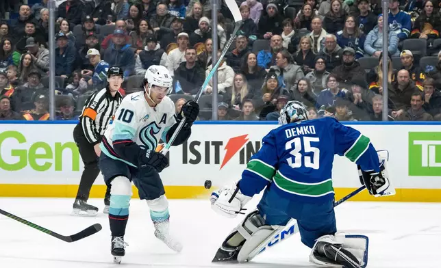 Vancouver Canucks goaltender Thatcher Demko (35) stops Seattle Kraken's Matty Beniers (10) during the first period of an NHL game in Vancouver, Friday, Jan. 2, 2026. (Ethan Cairns/The Canadian Press via AP)