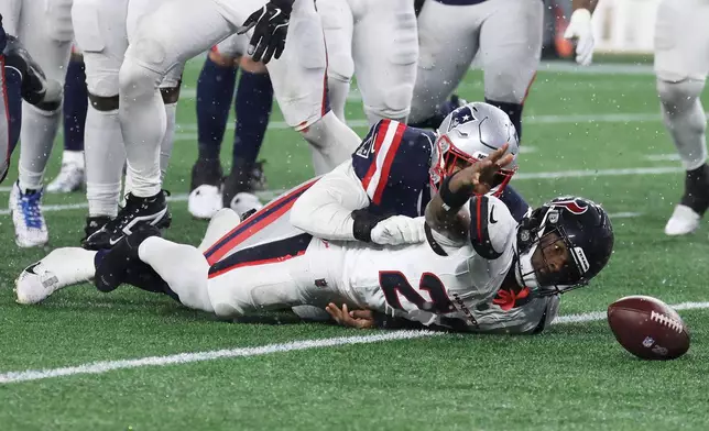 Houston Texans running back Woody Marks, bottom, looks toward the ball after fumbling, which was recovered by the New England Patriots, during the second half of an NFL divisional playoff football game, Sunday, Jan. 18, 2026, in Foxborough, Mass. (AP Photo/Mark Stockwell)